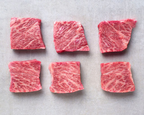 Six square-cut marbled wagyu pieces in two rows on a pale grey surface