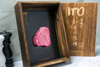 Raw marbled steak in an open wooden box with Ito lettering on its lid