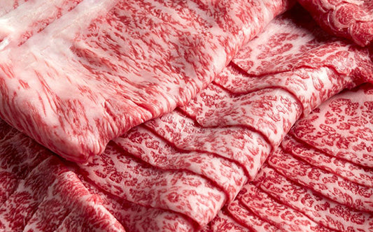 Close view of thin marbled wagyu slices layered in overlapping folds