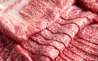 Close view of thin marbled wagyu slices layered in overlapping folds